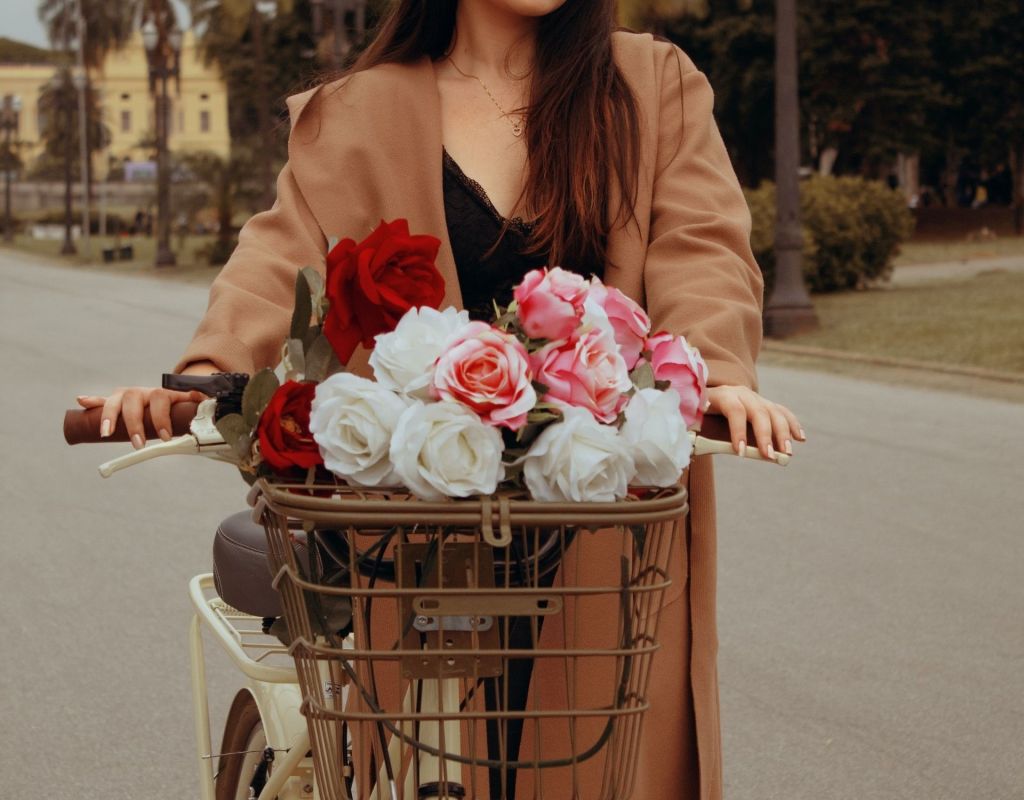 Frau mit Blumen im Fahrradkorb