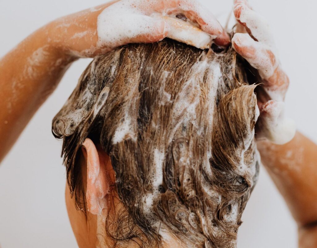 Frau wäscht sich Haare