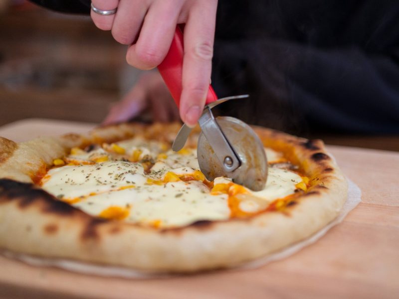 Mikrowellen Pizza Frau schneidet Pizza
