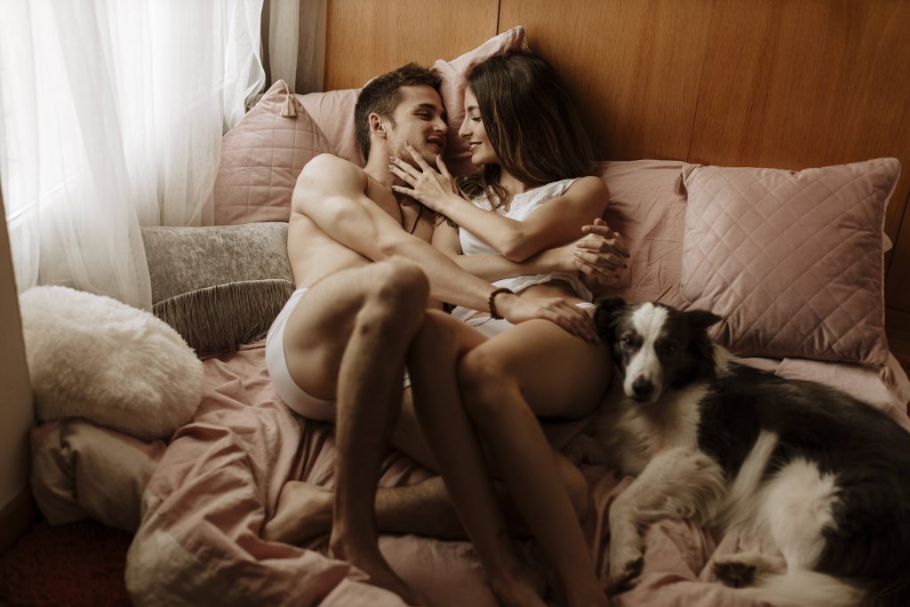 Hund im Bett mit Paar