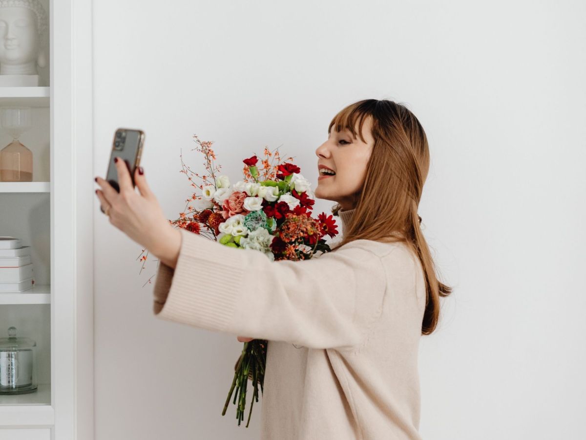 Frau macht Selfie mit Blumen