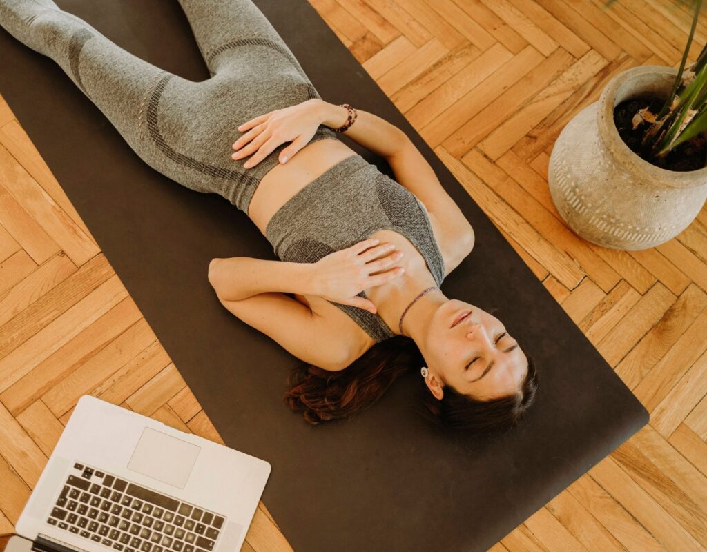 Frau liegt auf Yogamatte Schweiß