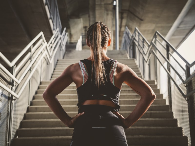 Sportlerin steht vor Treppe