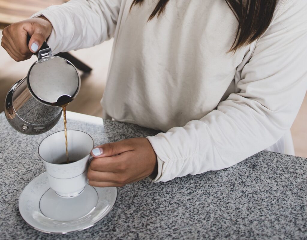 Frau schenkt Kaffee ein