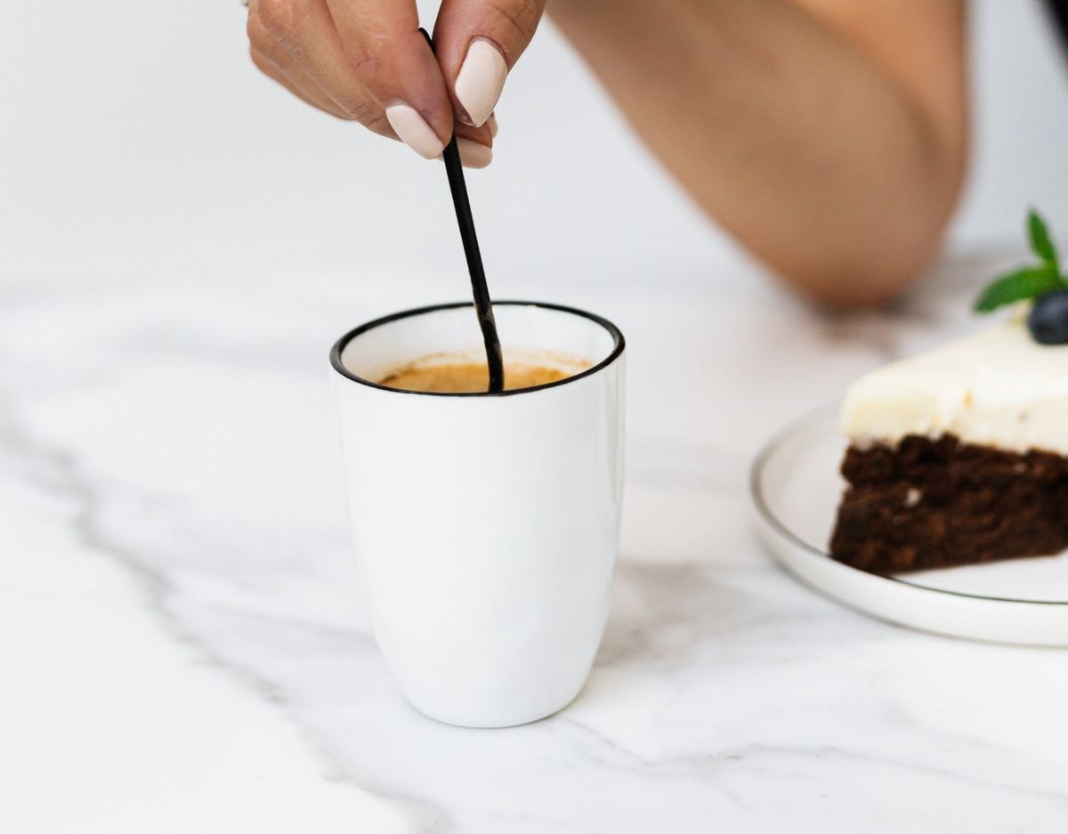 Hand rührt im Kaffee