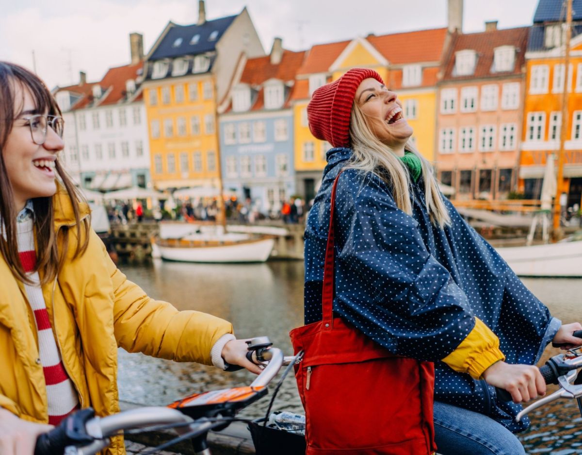 Geheimtipps für Kopenhagen zwei Frauen fahren Fahrrad Nyhavn