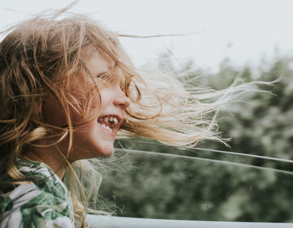 Kind Mädchen Auto Wind Haare Fenster