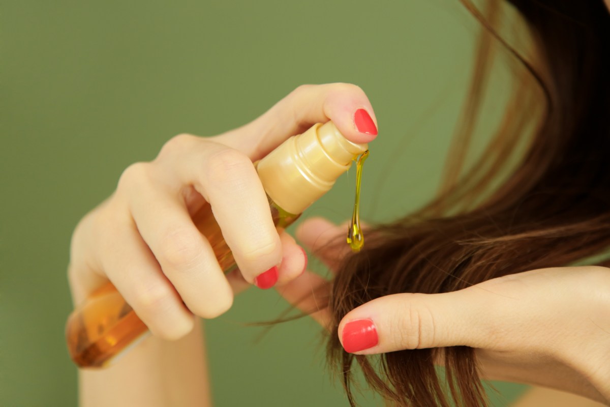 frau macht sich öl in die haare