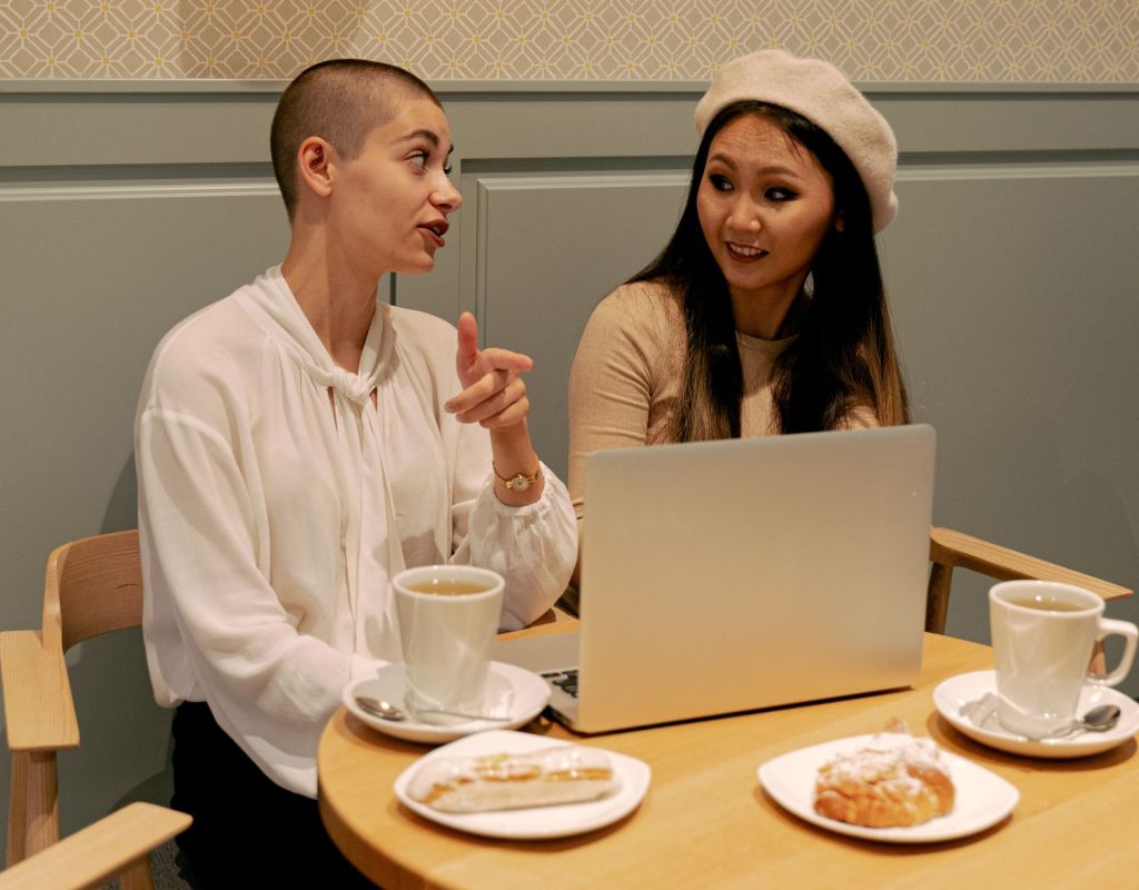 Zwei Frauen am Laptop mit Kaffee