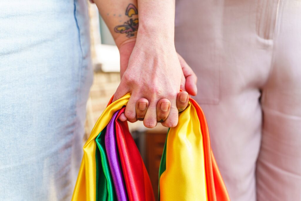 Zwei Personen halten die Regenbogenflagge