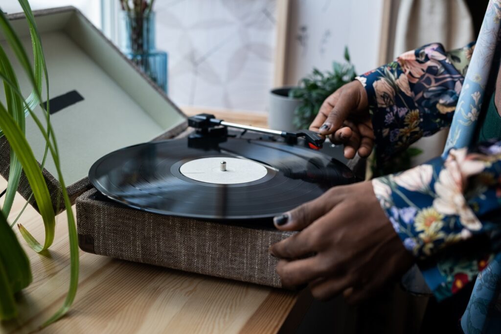 Hände mit schwarzem Nagellack legen Vinylplatte auf