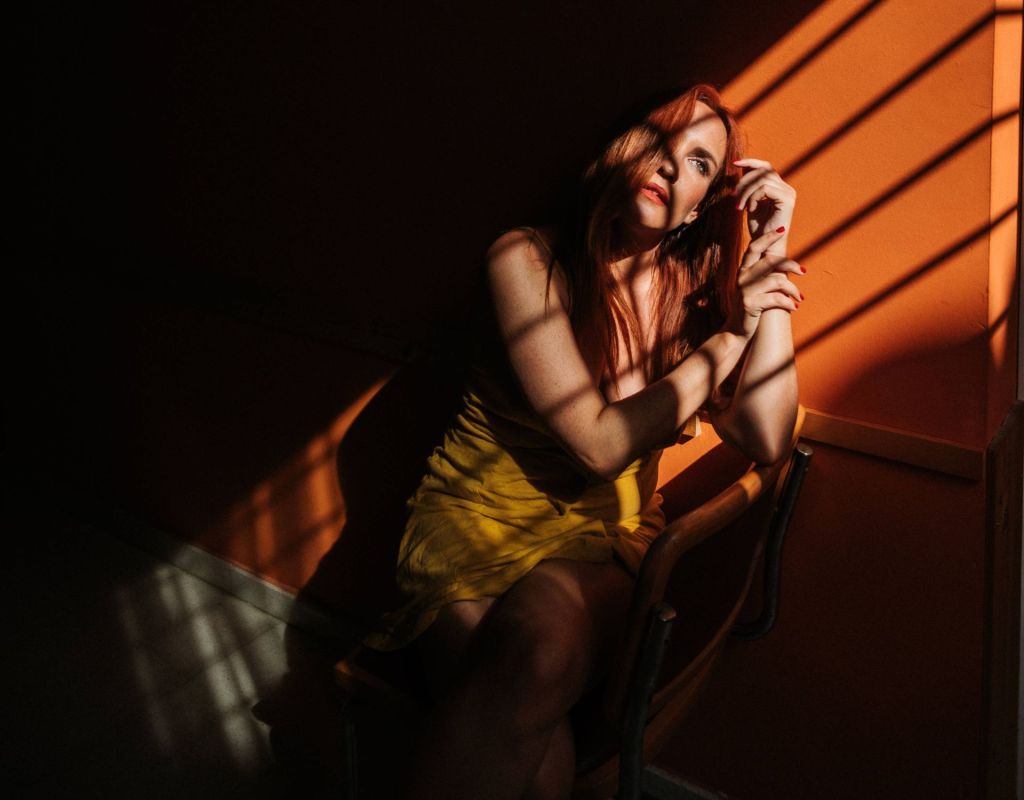 Frau allein im Raum mit Sonnenstrahlen