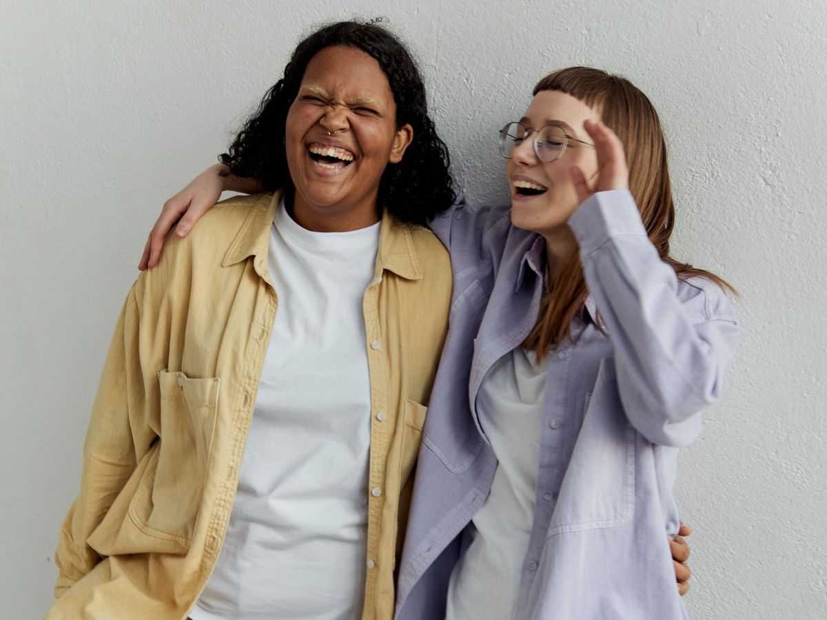 Zwei Frauen stehen nebeneinander und lachen