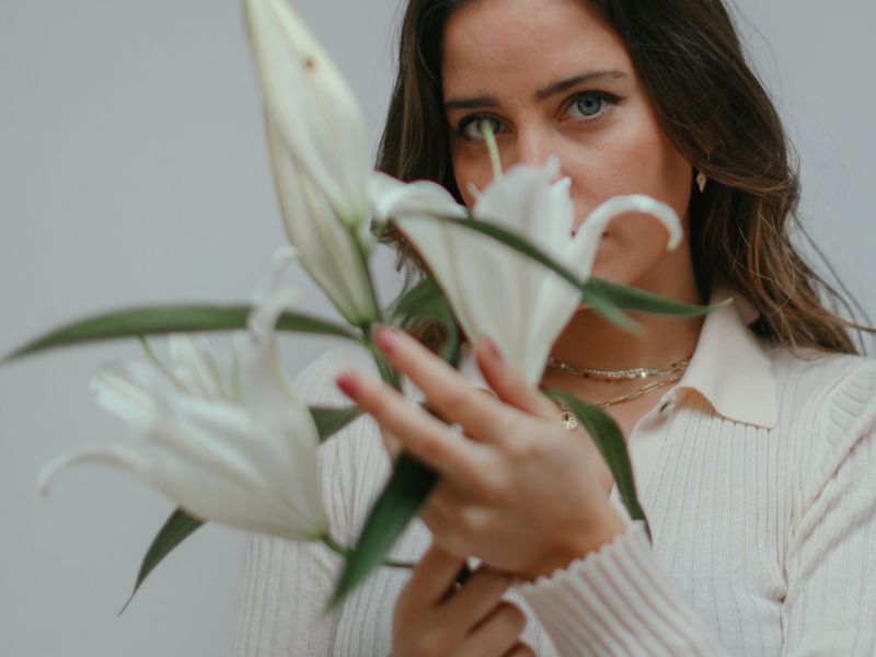 Frau mit Blumen vorm Gesicht