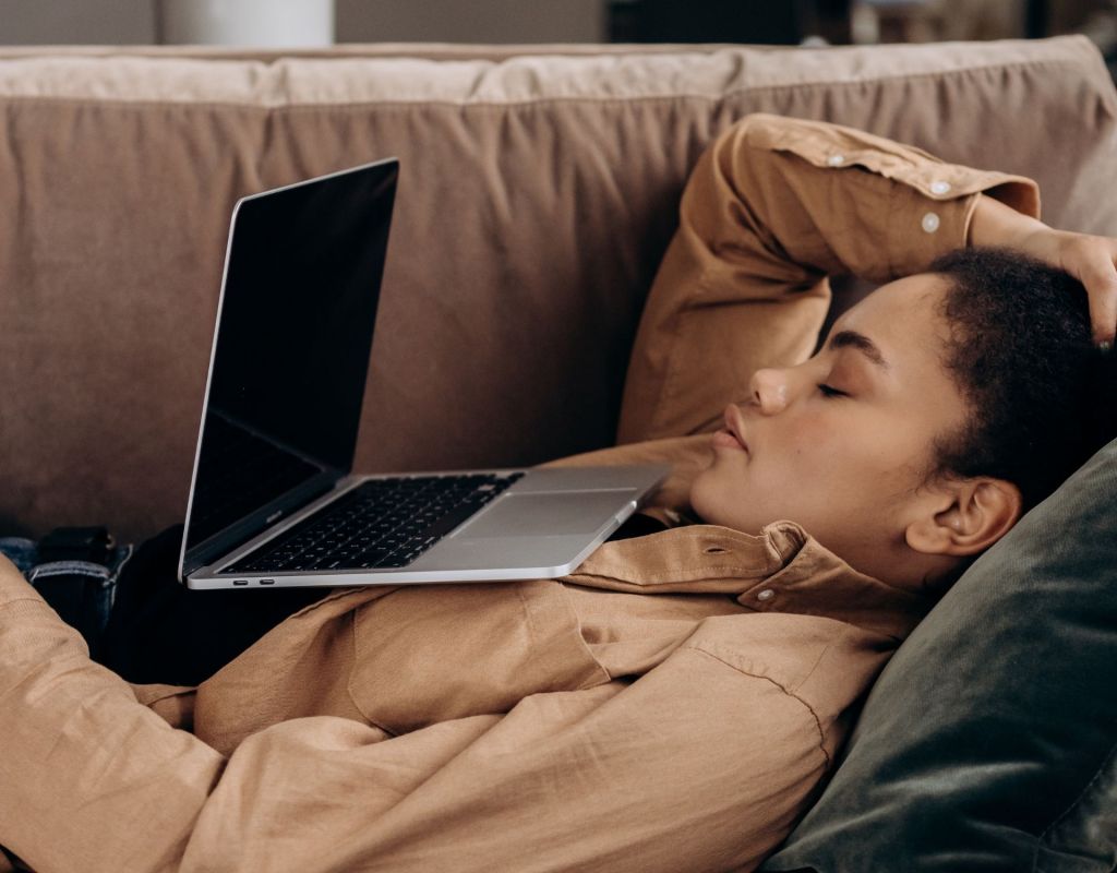 Frau schläft vor Laptop