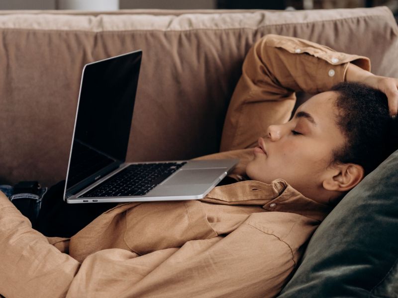 Frau schläft vor Laptop