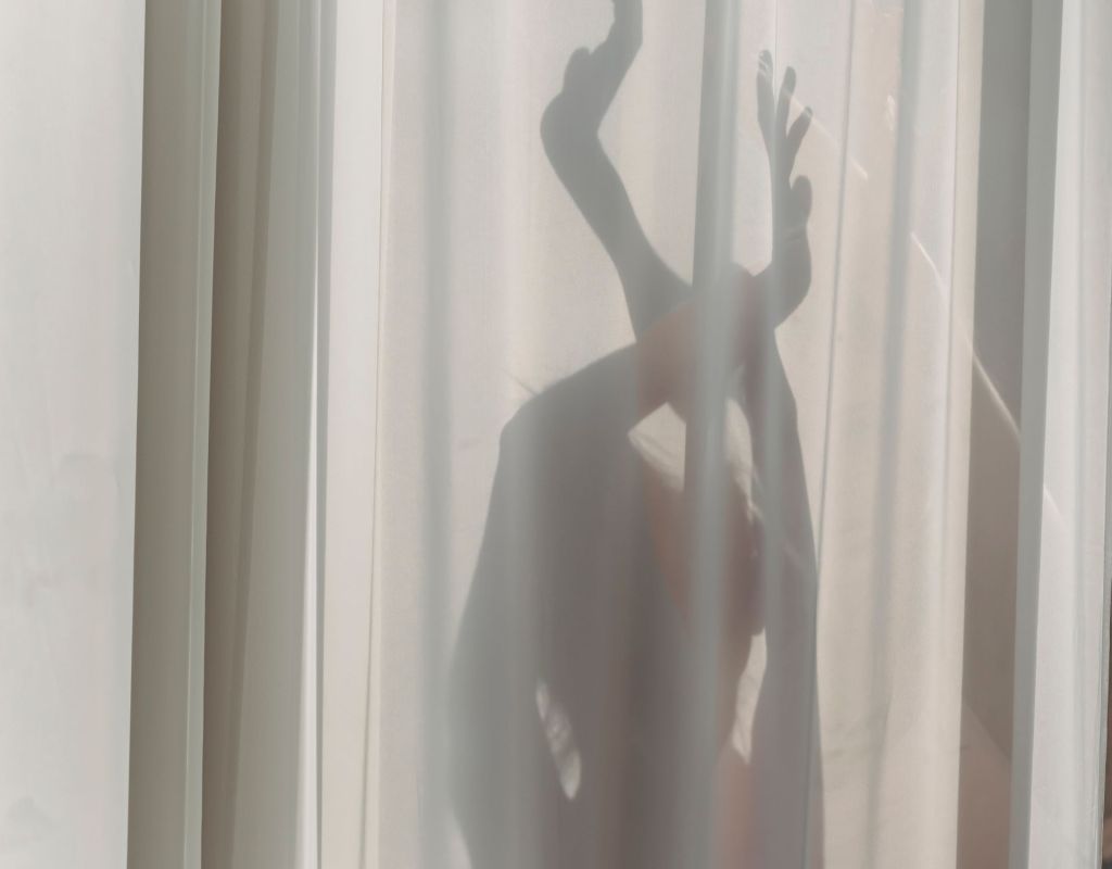 Schatten von Frau hinter einem Vorhang