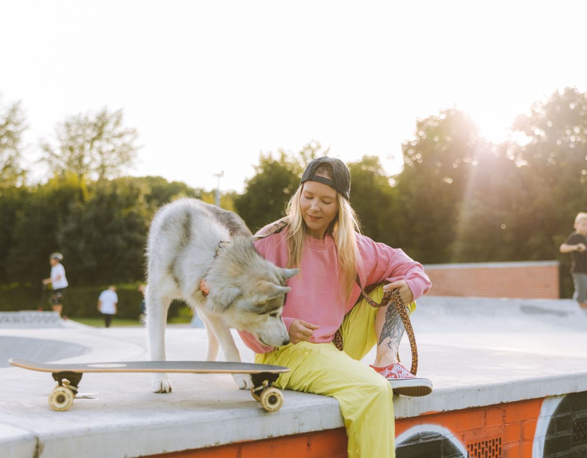 Frau mit Husky auf Skateboard