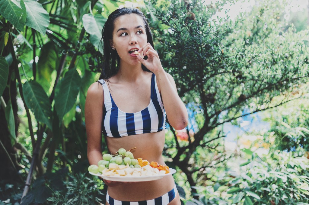 woman in bikini with fruit plate