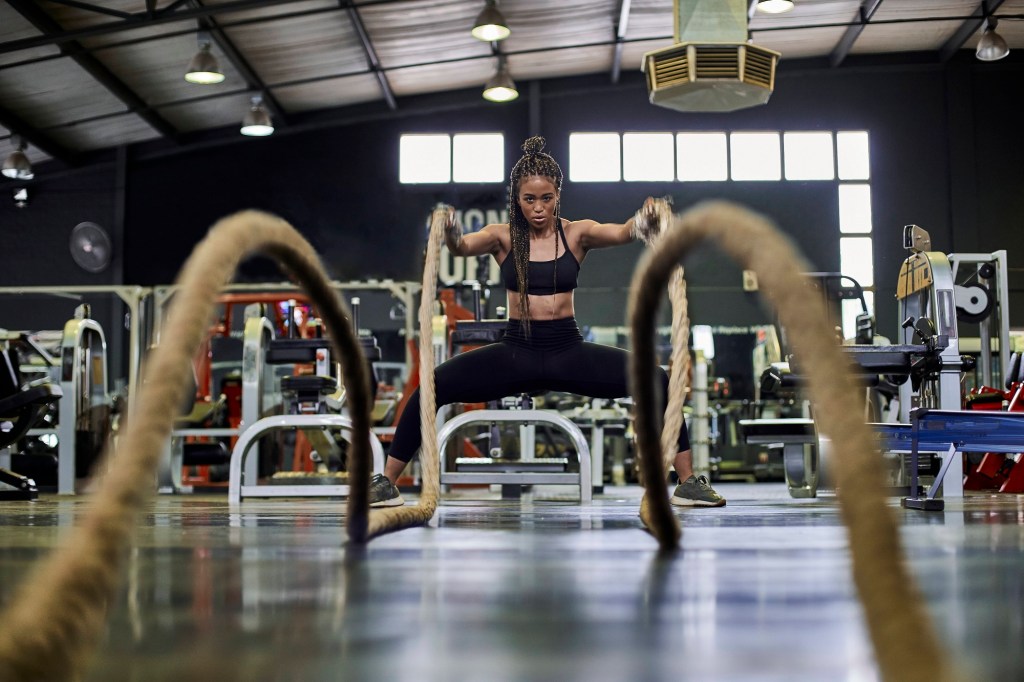 Frau trainiert mit Heavy Ropes