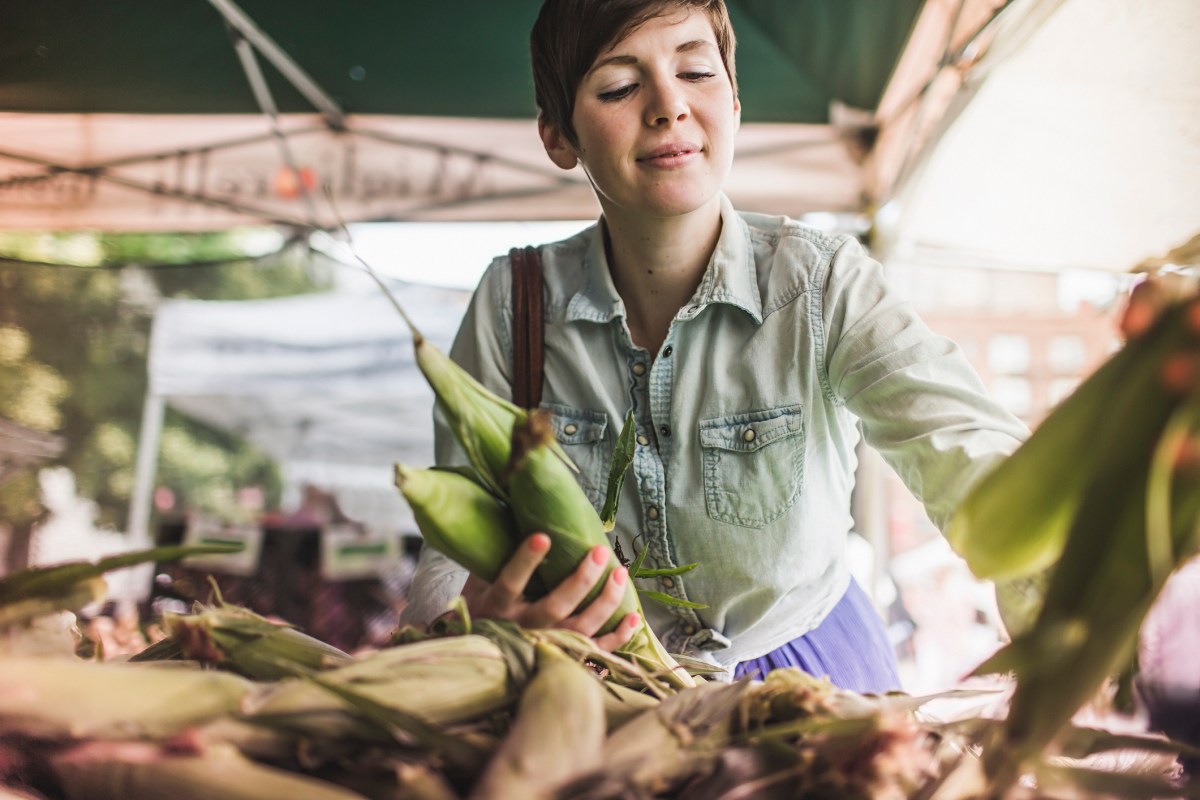 Frau kauft auf Wochenmarkt ein