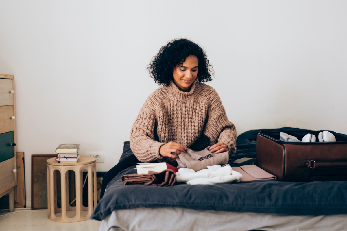 Frau am Koffer packen