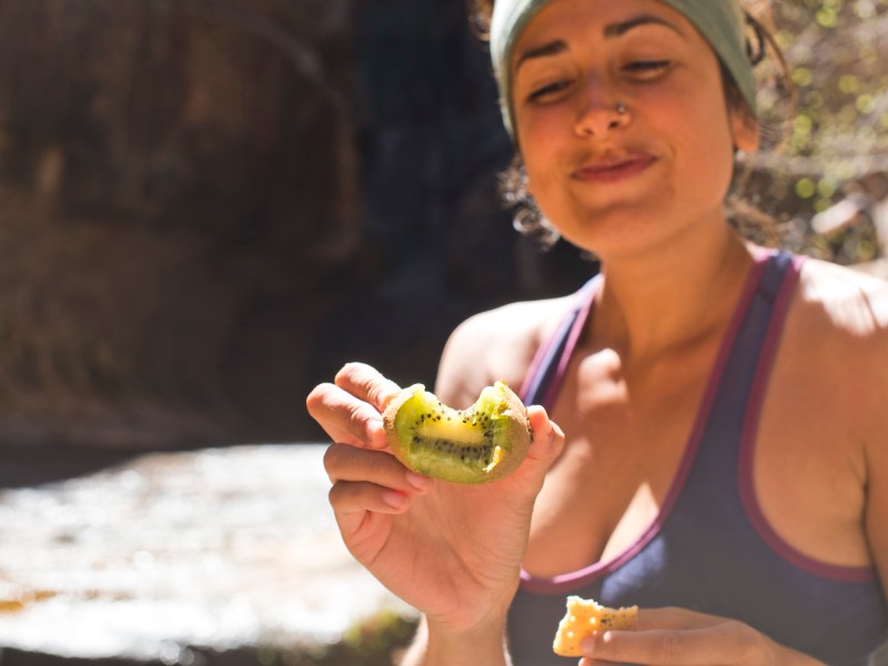 Frau isst Kiwi