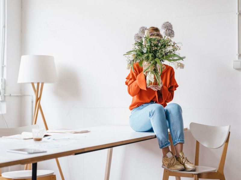 Jobs für Introvertierte Frau versteckt sich hinter Blumenstrauß