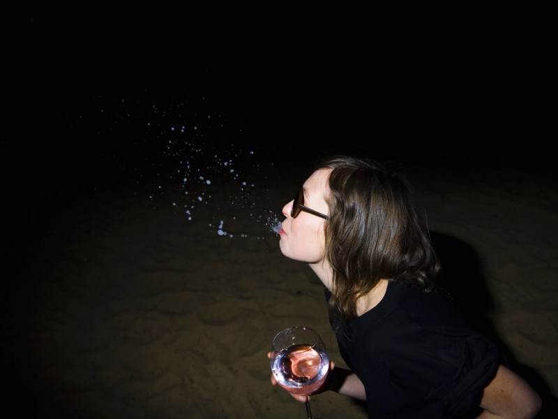 Frau spuckt Alkohol aus