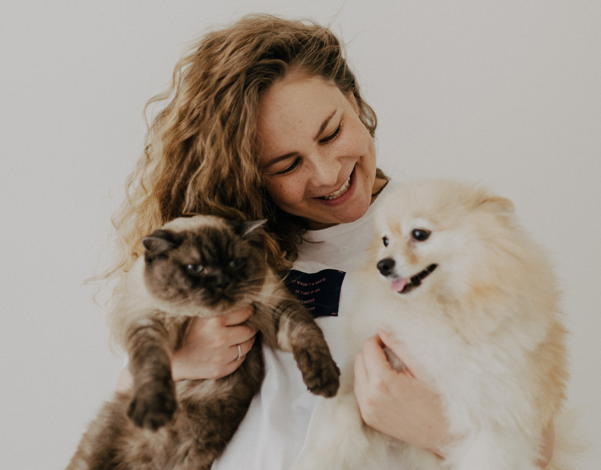 Frau mit Hund und Katze auf dem Arm.