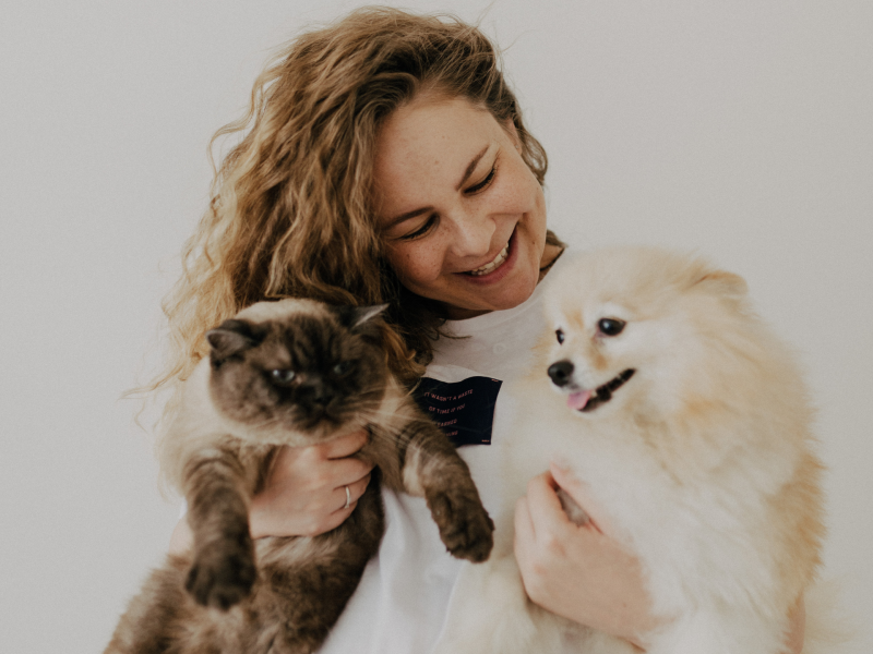 Frau mit Hund und Katze auf dem Arm.