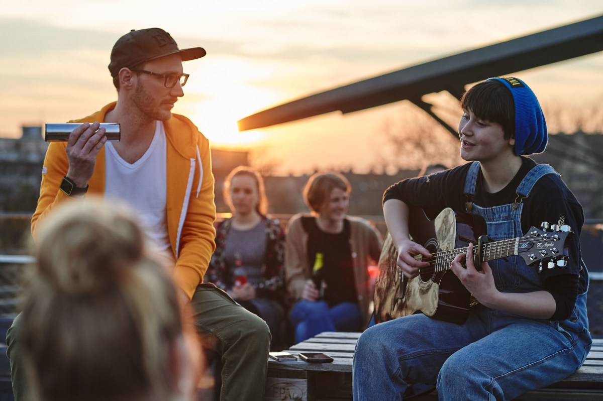 Eine Musikerin spielt Gitarre. Für ihre Buchhaltung nutzt sie lexoffice.