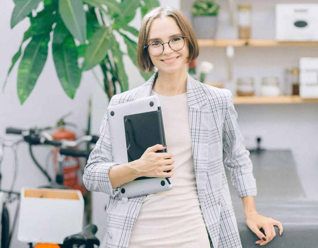 Frau mit Laptop unter dem Arm