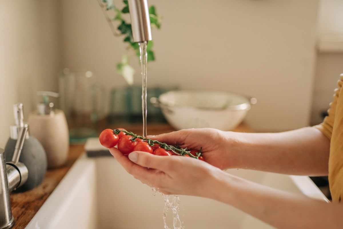 Frau wäscht Tomaten