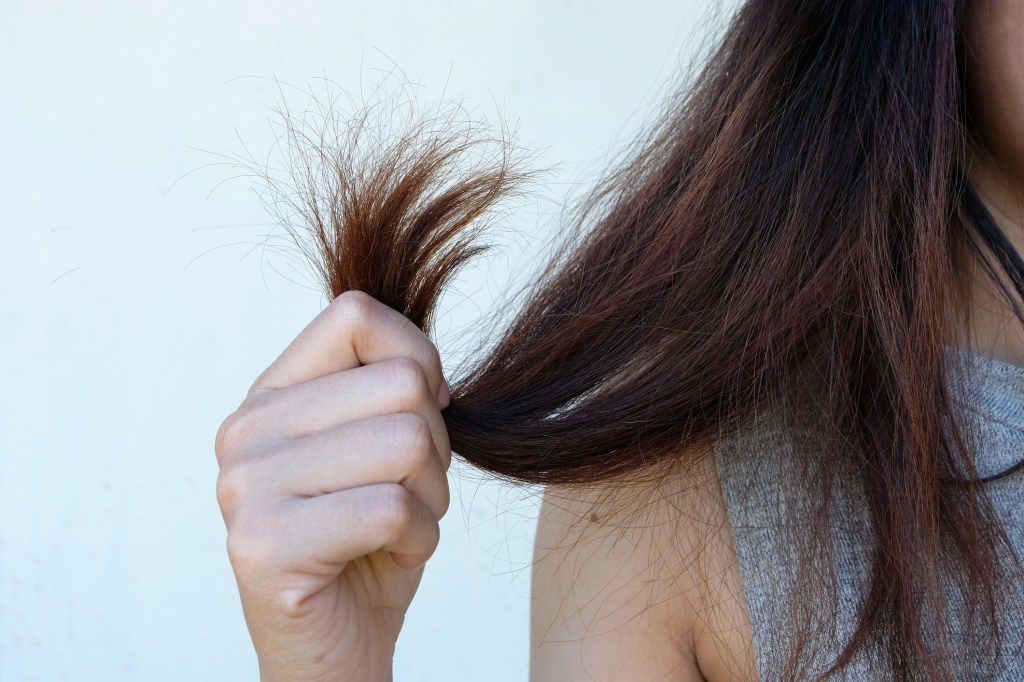 frau hält haare in der hand