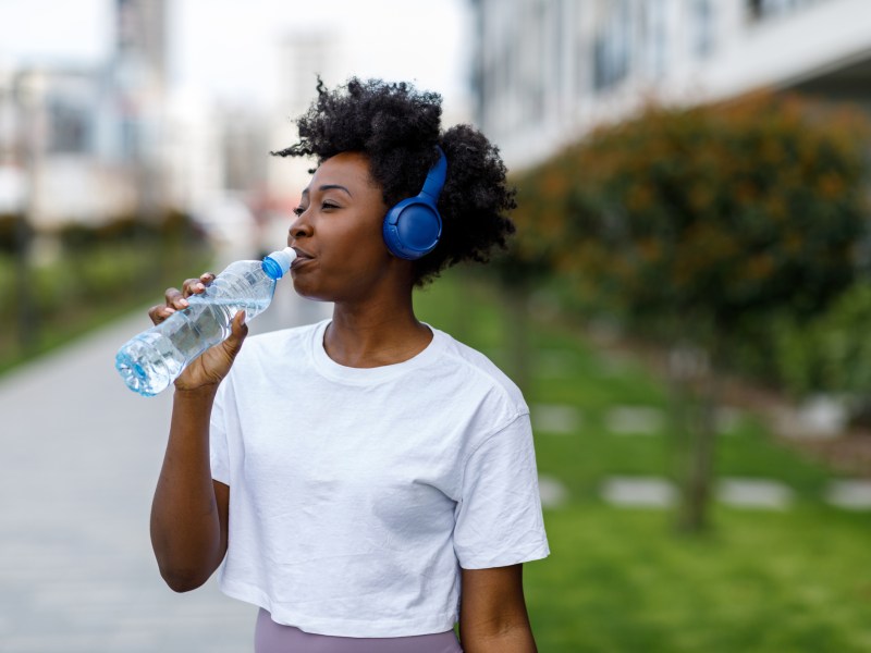 Frau Wasser im Stehen trinken