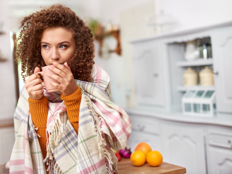 Frau Tee trinken Decke Erkältung