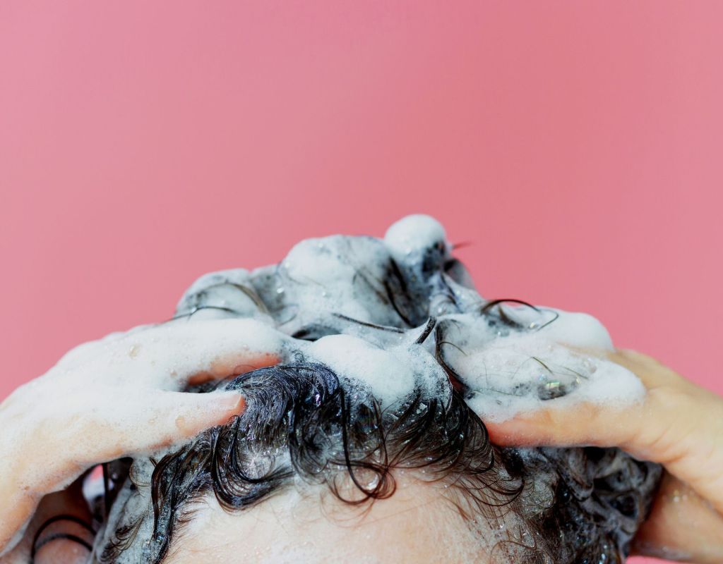 Frau shampooniert sich die Haare