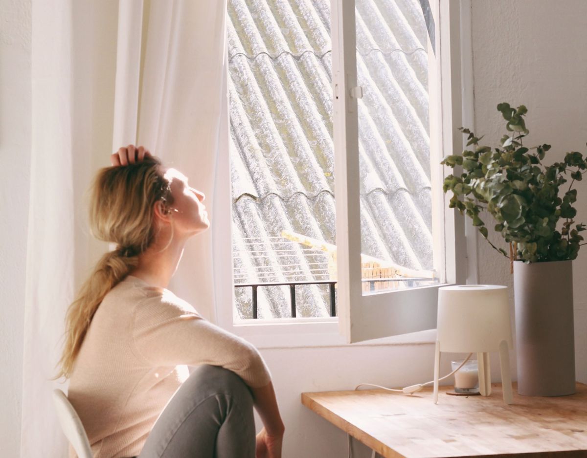 Frau am geöffneten Fenster