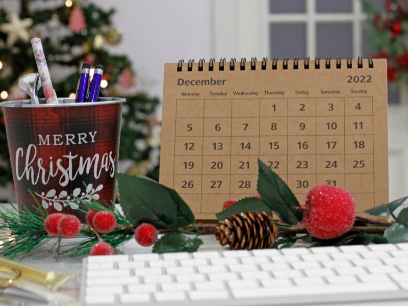 Ein Kalender mit dem Monat Dezember steht auf einem Bürotisch.