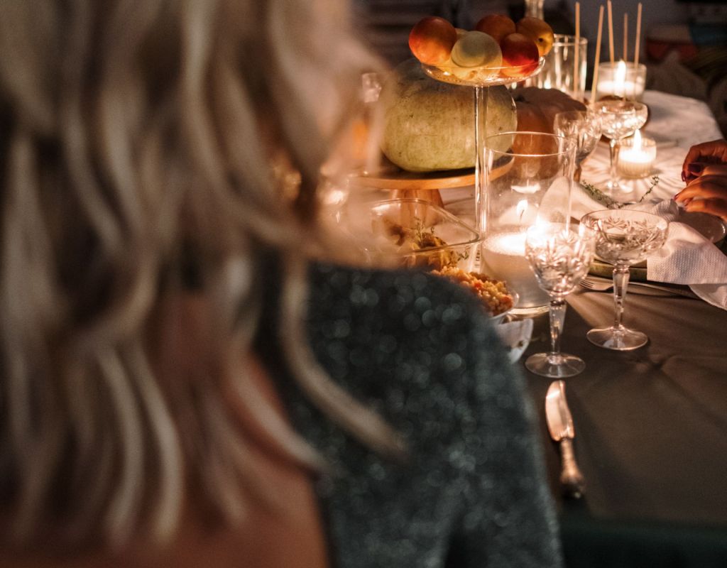 Frau am Esstisch mit Kerzen