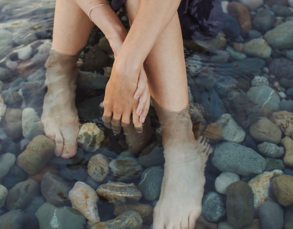 Frau mit den Füßen im Wasser