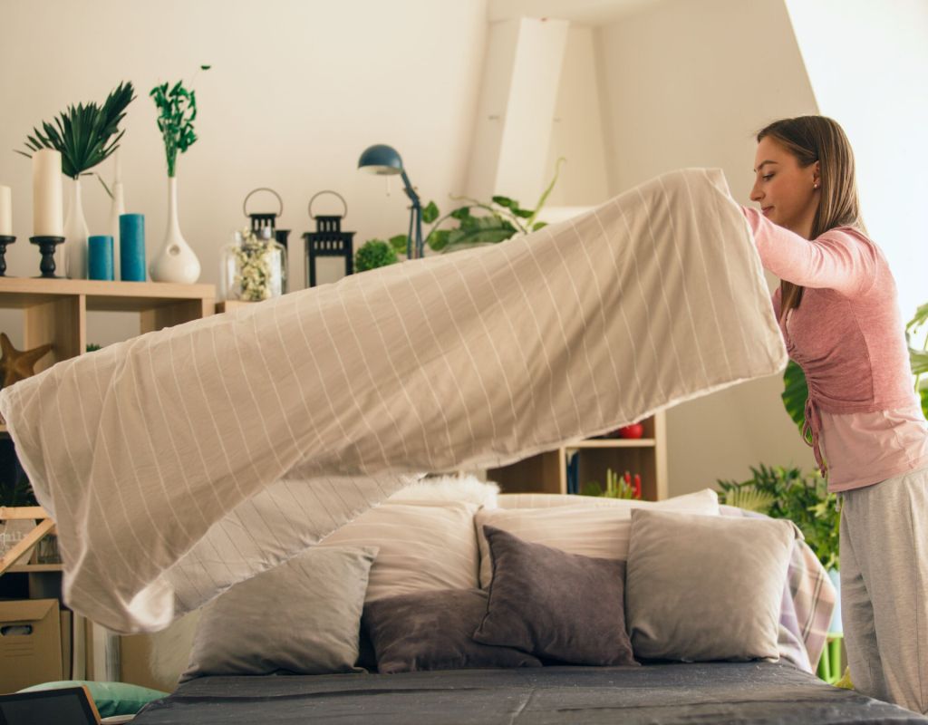 Frau schüttelt Bett auf