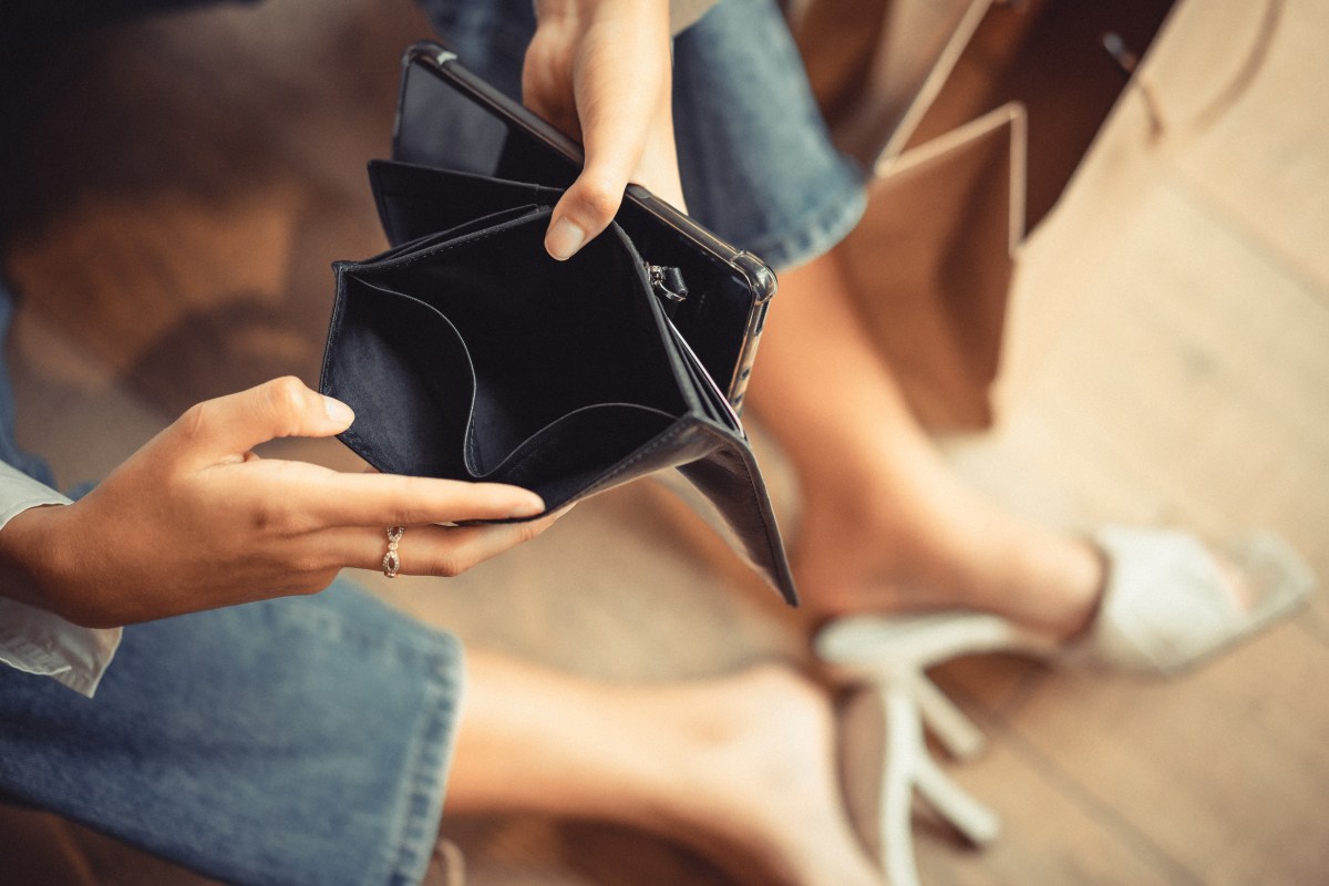 Frau hält leeres Portemonnaie in der Hand.