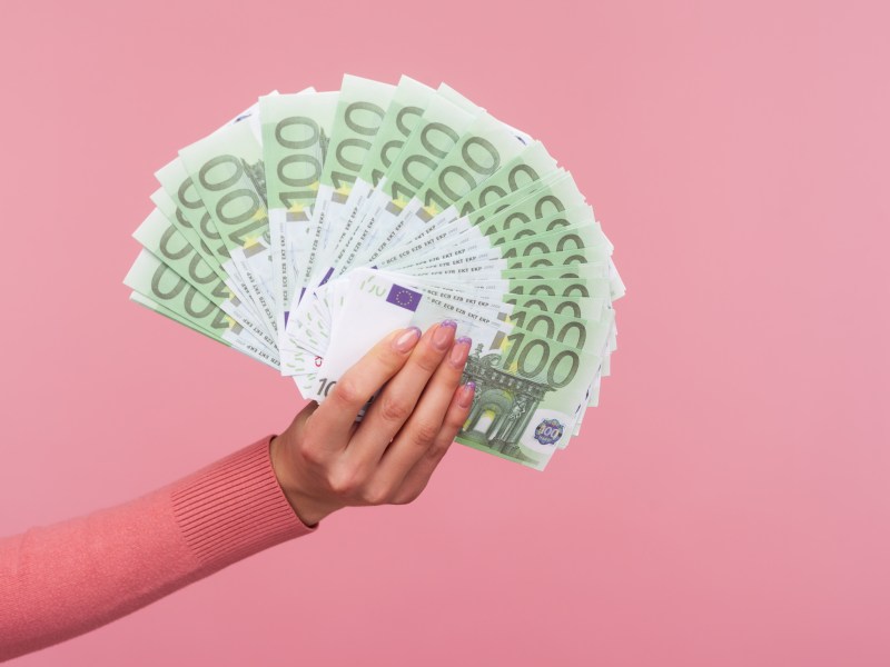 Frau hält 100-Euro-Scheine in der Hand