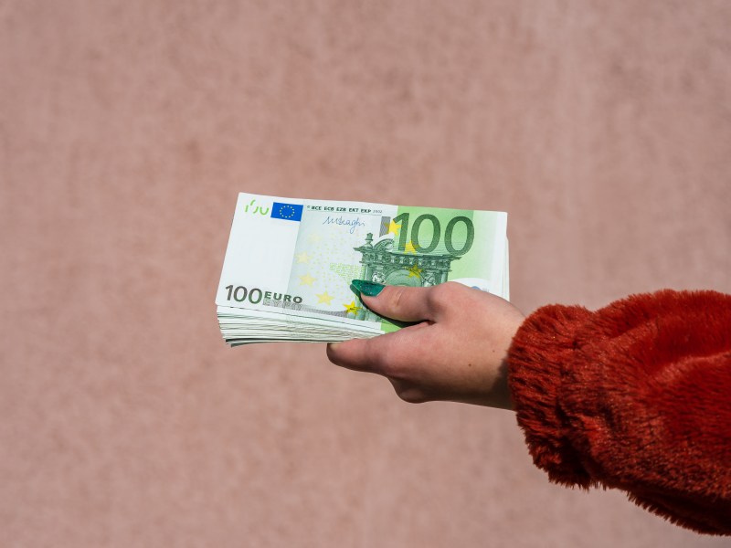 Frauenhand mit 100-Euro-Scheinen