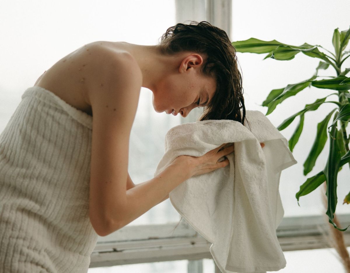 Frau trocknet sich mit Handtuch die Haare