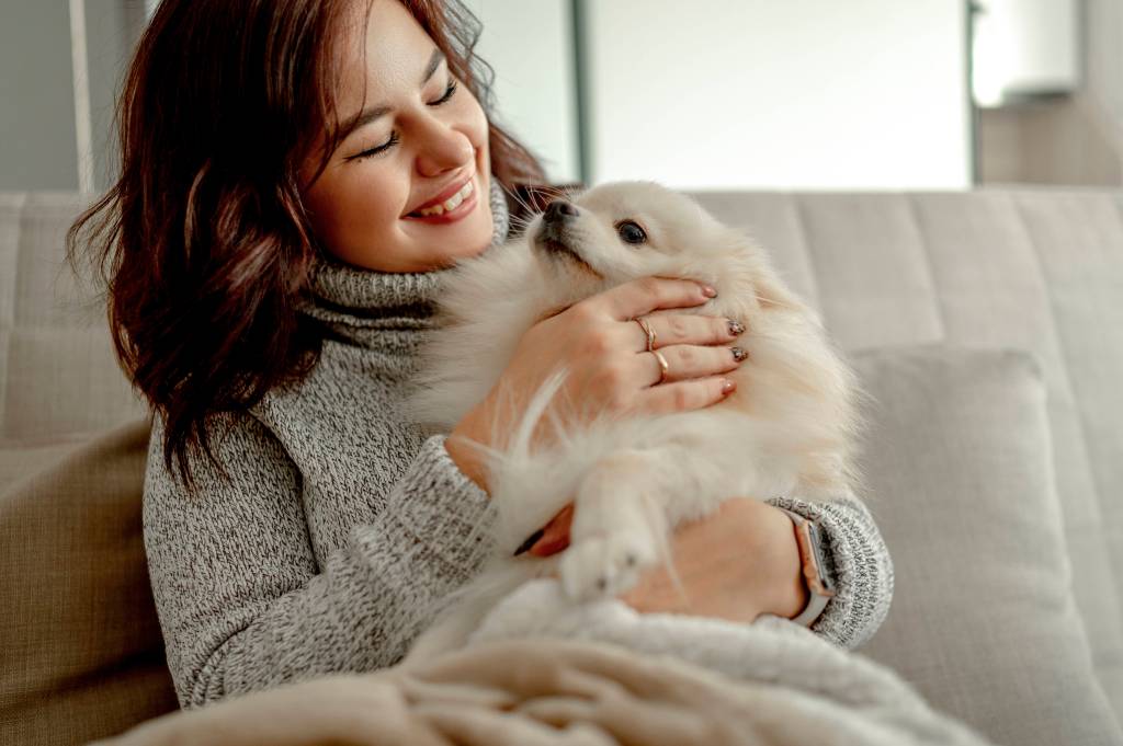 Frau kuschelt mit Hund