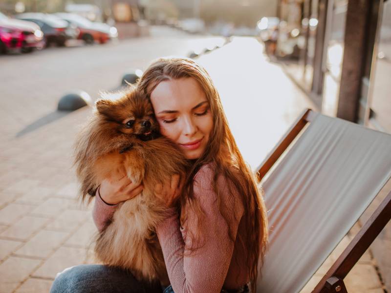 Frau kuschelt Hund