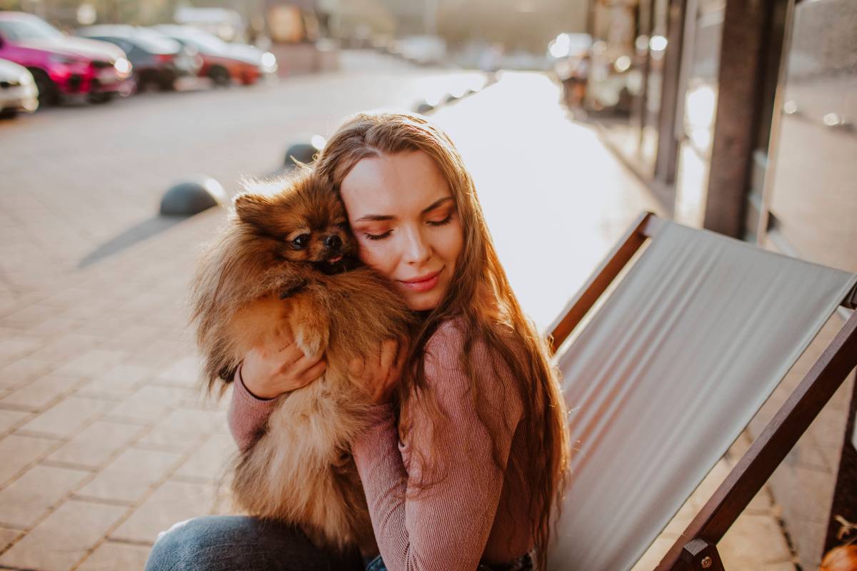 Frau kuschelt Hund